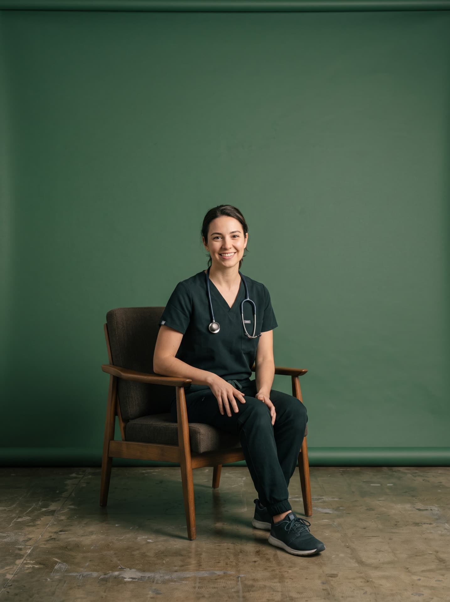 A smiling vet nurse in dark scrubs with a stethoscope